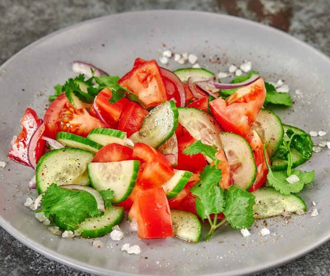 Салат из спелых томатов, огурцов и сезонной зелени